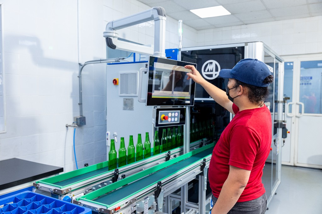 SAGCO technician operating automated green-bottle inspection equipment